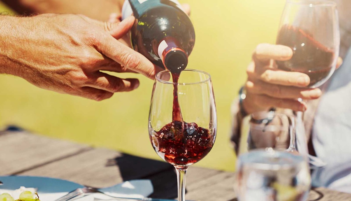 person pouring a red wine